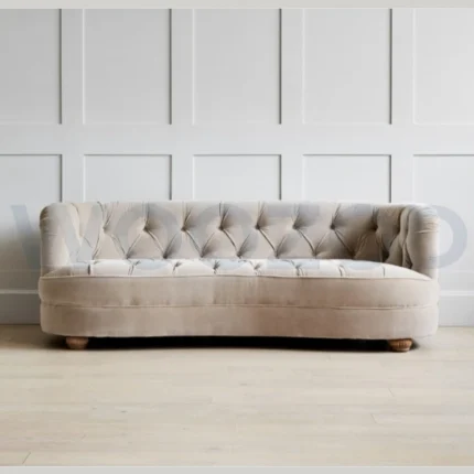 Beige velvet 3-seater sofa with curved silhouette and oak-brown wooden legs.